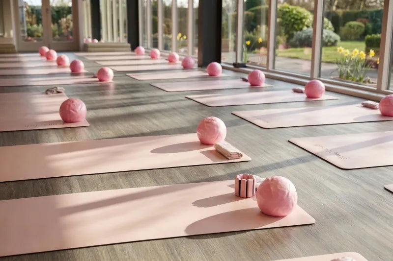 Pink pilates mats and balls set up in a light filled studio - The Sculpt Club mat Pilates classes East Lothian