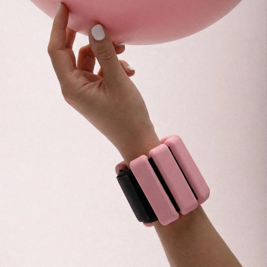 TSC rose pink wrist weights worn holding a pink pilates ball - The Sculpt Club accessories